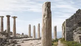 Ancient stone ruins set against rolling hills, representing early Western architecture.