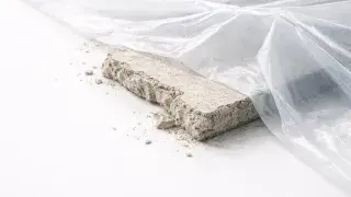 Asbestos encapsulation detail showing sealed insulation board under polyethylene sheeting.