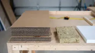 Improvised cardboard insulation test in framed mockup next to proper materials like mineral wool and rigid foam, construction comparison.
