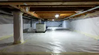 Fully encapsulated crawl space with white vapor barrier, sealed piers, and dehumidifier.