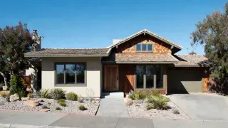 Modest contemporary house showcasing practical green building practices with deep roof overhangs and high-performance windows.