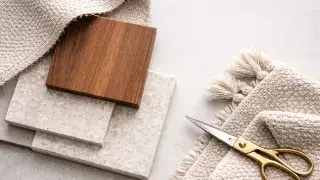 Materials and textiles in interior design with fabric swatches, wood sample, and stone tile.