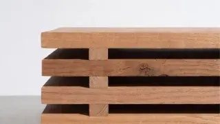 Wood boards stacked with spacer sticks to acclimate indoors.