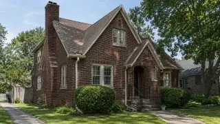 Authentic 1930s brick house exterior with steep gables, original windows, and front stoop.