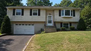 Dated raised ranch exterior with worn lawn, plain stairs, and weak front entry before remodeling.