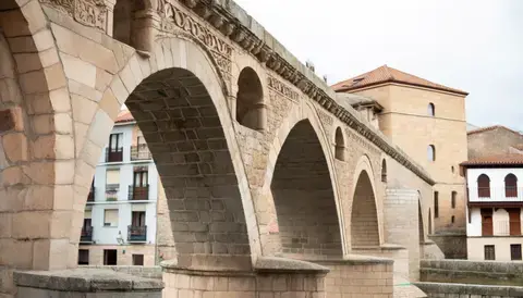 Ancient stone bridge with arches and intricate carvings.