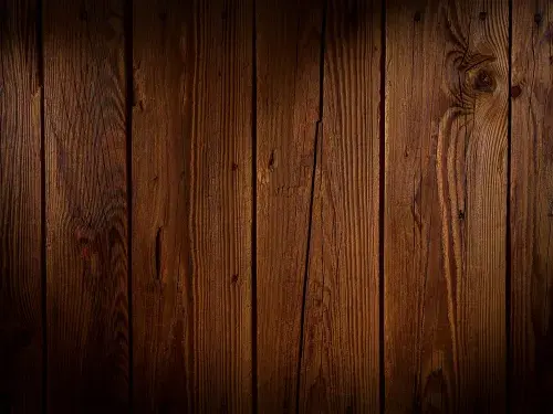 Close-up of a rich, detailed wood surface showing grain patterns and texture.