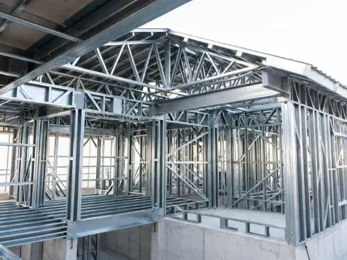 Cold-formed steel house frame with steel roof trusses over the main volume.