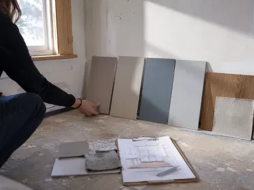Interior designer testing paint colors with wood, fabric, and stone finishes.