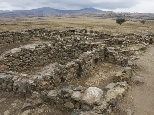 Early stone settlement walls in a dry archaeological landscape.
