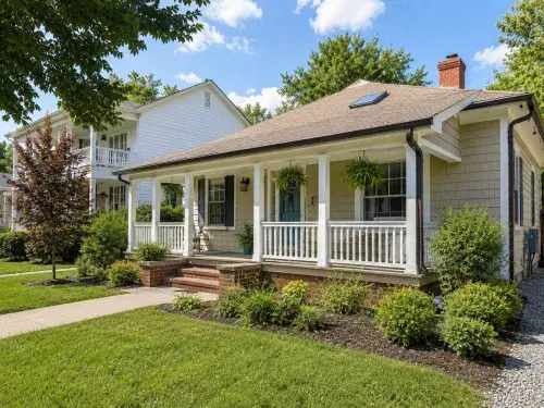 American bungalow with deep front porch, low roof, and modest front yard.
