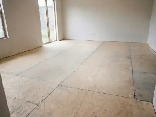 Exposed OSB subfloor in an empty room before finish flooring is installed.