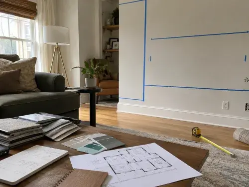 Interior design planning setup with room measurements, material samples, floor plan, and furniture layout.