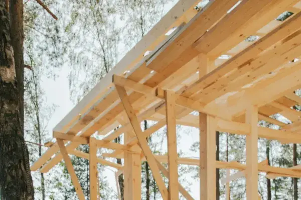 A real house under construction showcasing truss lateral bracing spanning across the wooden frame for structural stability.