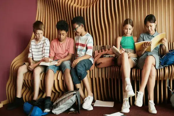 Kids sitting on a bench with architectural design, engaging in a hands-on learning experience about architecture.