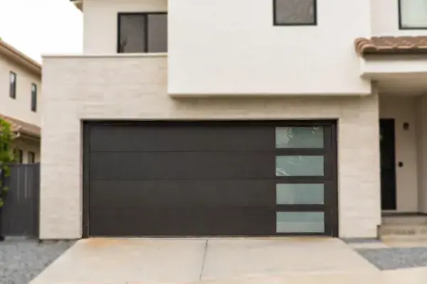 Modern garage door with dark panels, vertical frosted glass inserts, and warm wood trim.