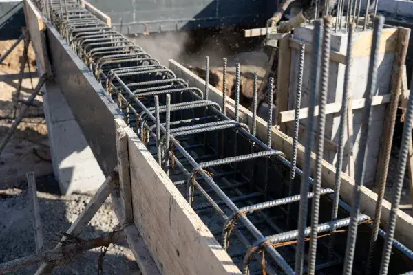 Reinforced concrete tie beam formwork with rebar cage before pour.
