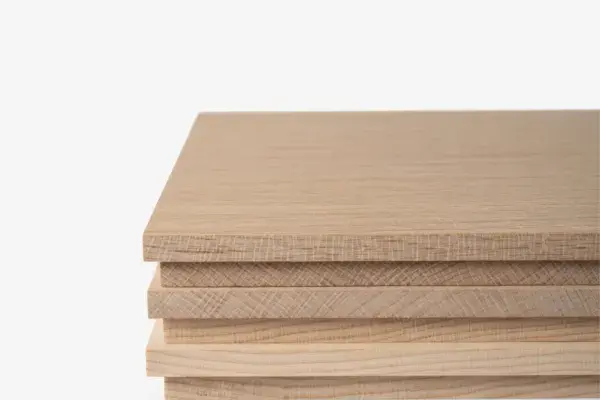 Stack of hardwood boards with visible face grain and end grain on a white background.