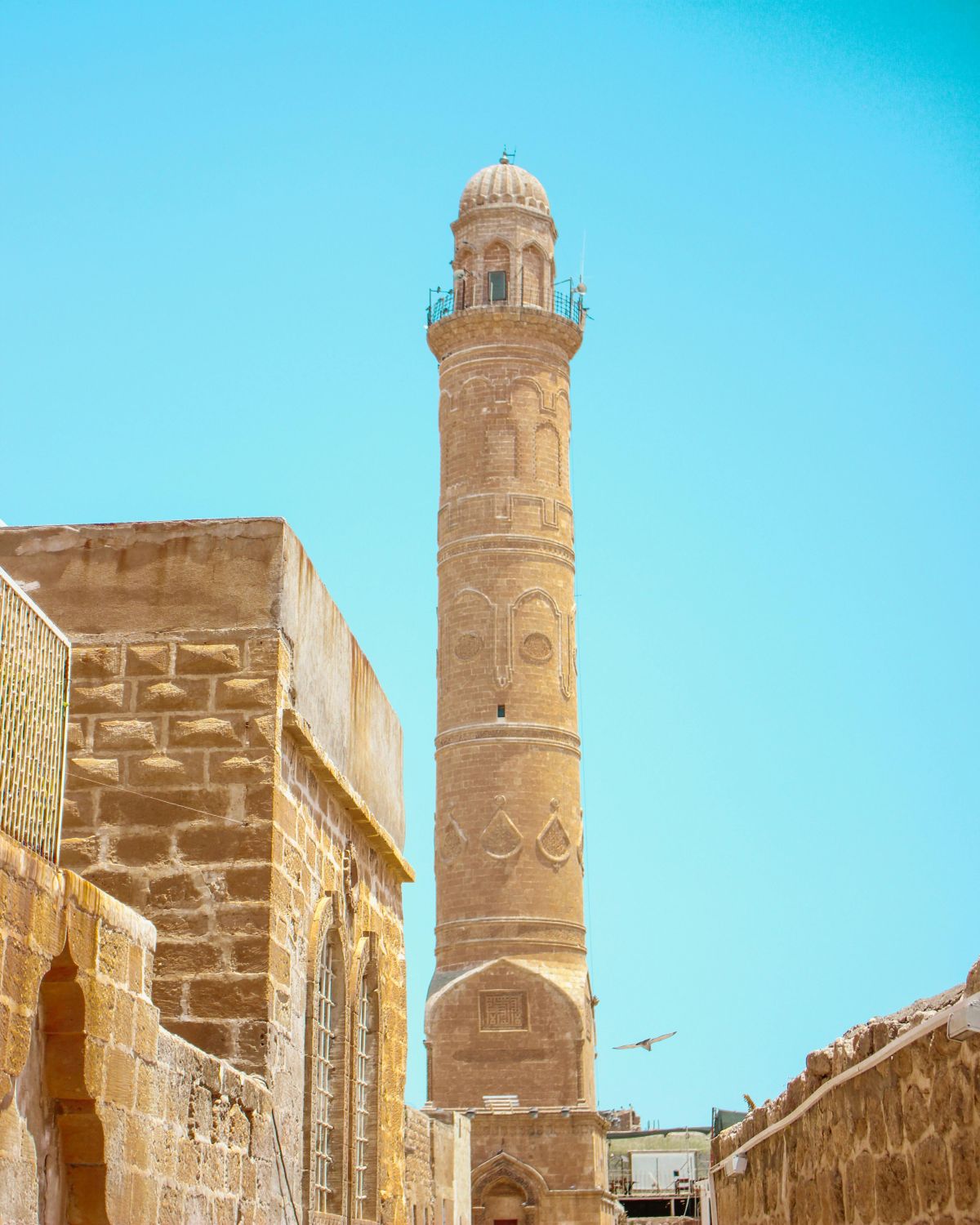 The elegant stone minaret of the Mardin Grand Mosque, showcasing intricate carvings.